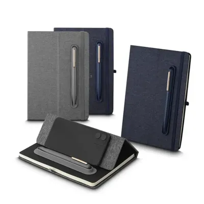 Caderno produzido com capa em tecido RPET e suporte para caneta em latão reciclável na capa, capa dobrável para suporte de smartphone, miolo com 80 folhas pautadas.